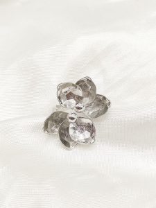 ANILLO DOS MITADES DE FLORES FACETADAS